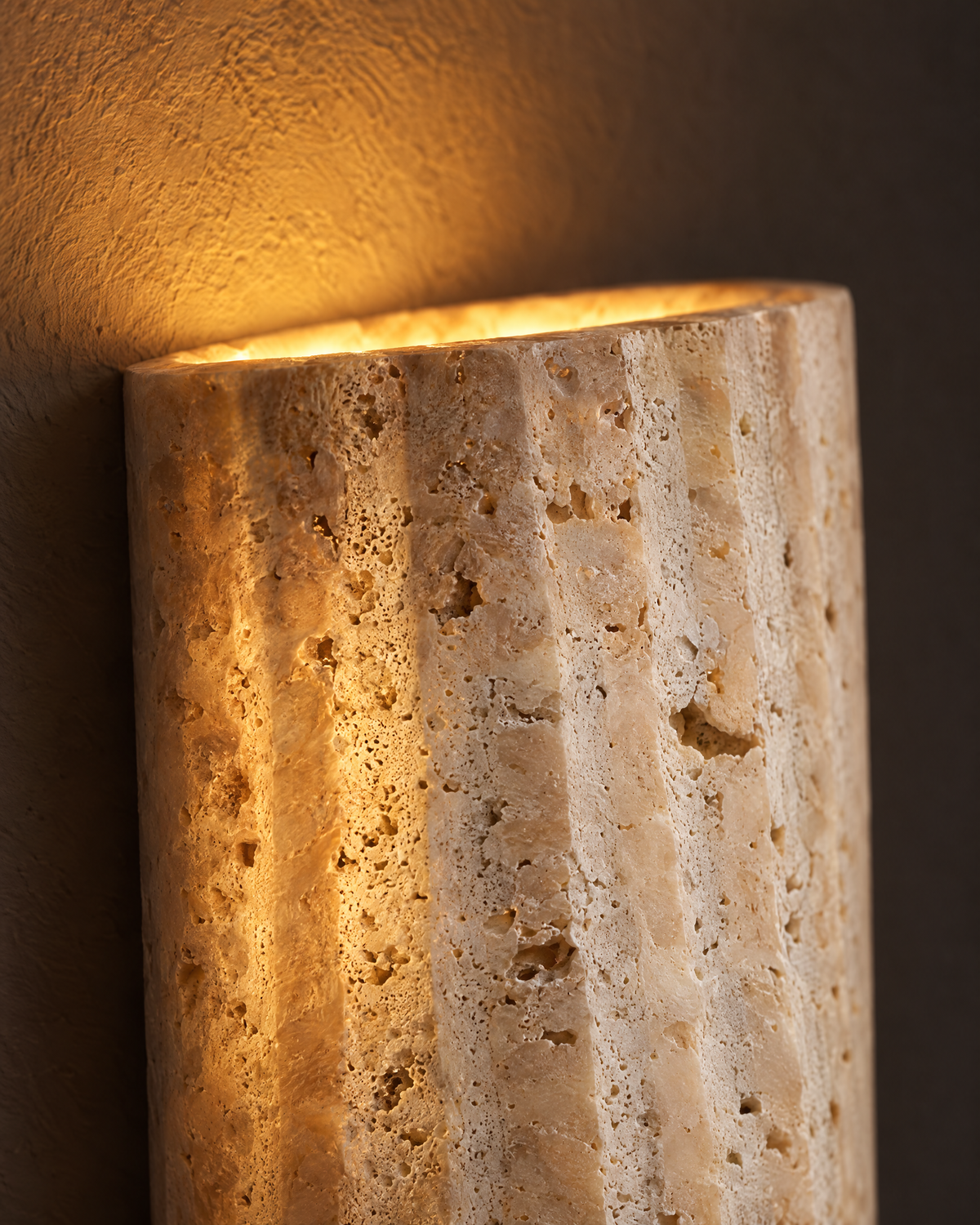 Close-up of the porous natural stone surface with warm light escaping from the top